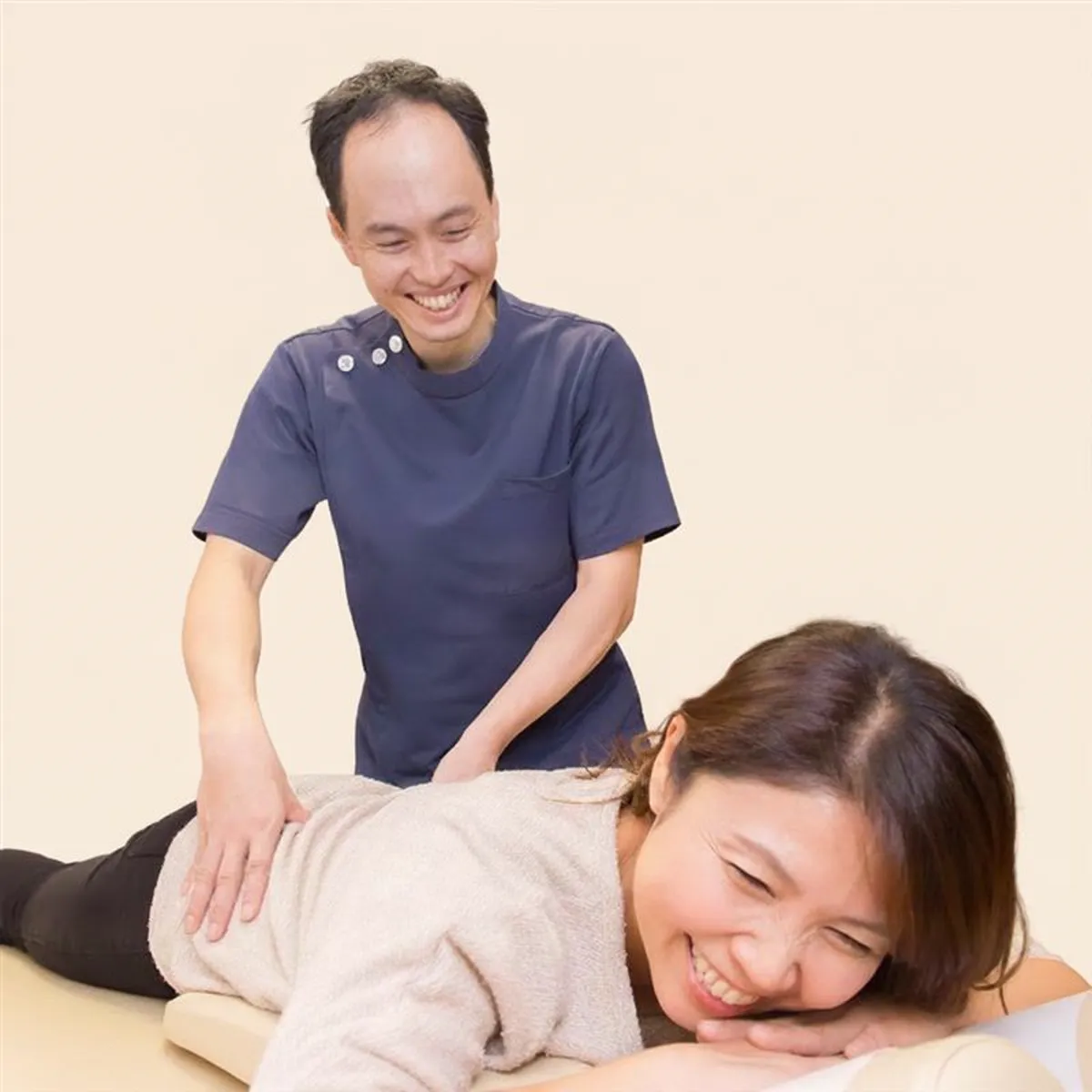 うつ伏せで施術を受けながら、院長と笑顔で話す女性患者