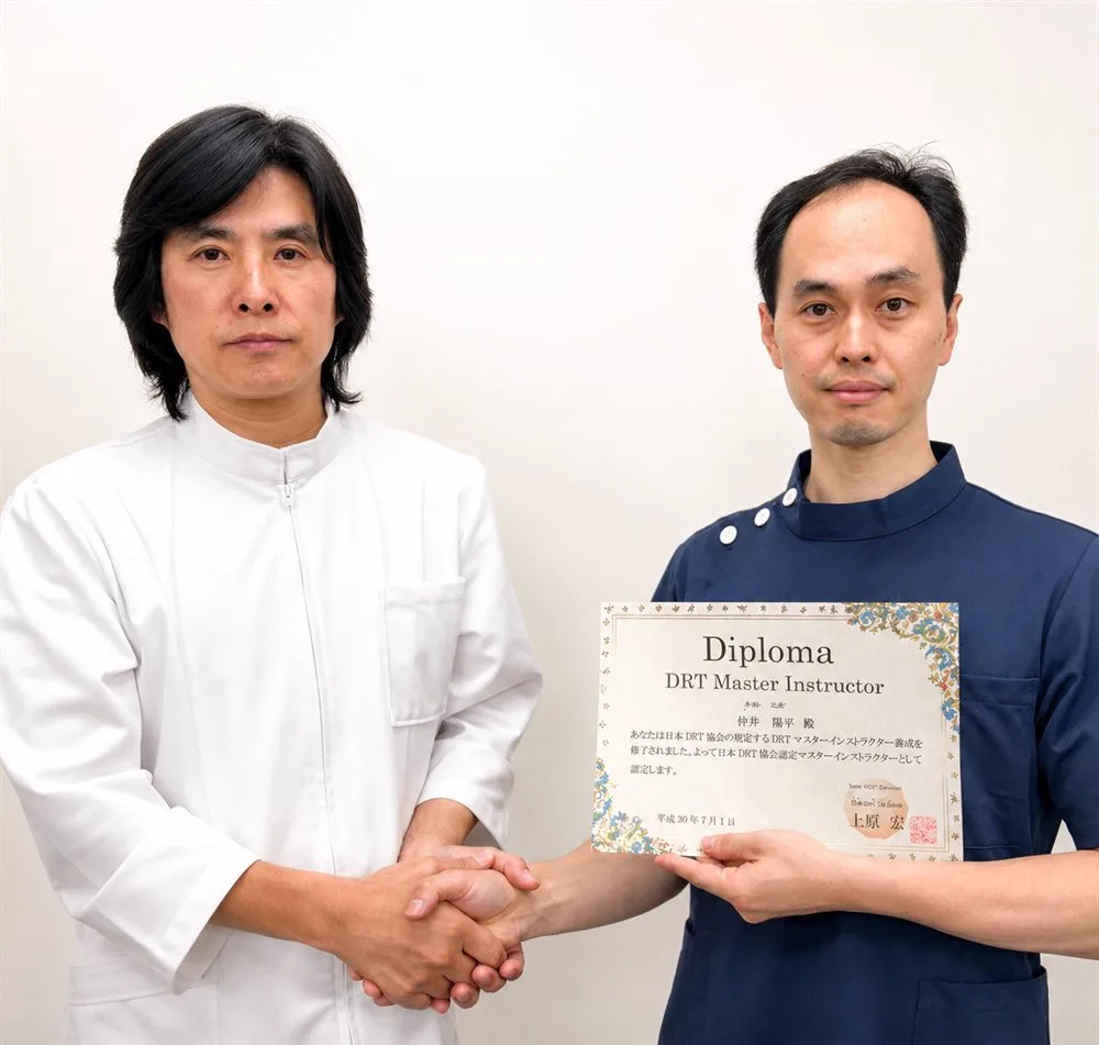 DRT開発者・上原宏先生（左）から、院長がDRTマスターインストラクターの認定を受けた際の様子
